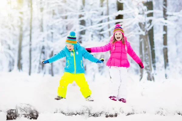 Karda oynayan çocuklar. Çocuklar açık havada kış kar yağışı oynamak. — Stok fotoğraf