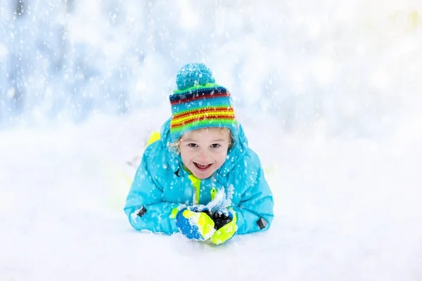 Kind spelen met sneeuw in de winter. Kinderen buiten. — Stockfoto