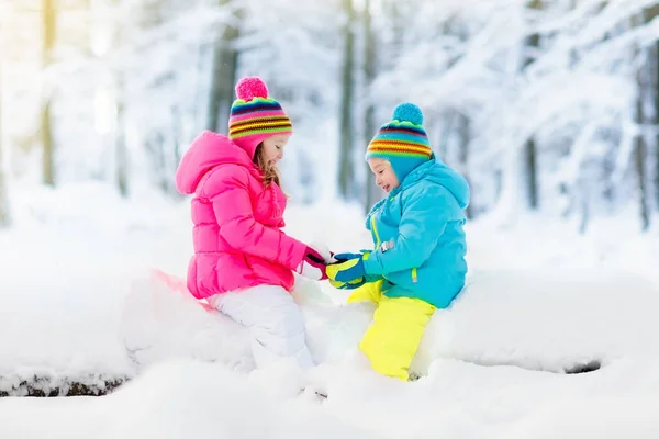 Crianças brincando na neve. Crianças brincam ao ar livre no inverno snowfall . — Fotografia de Stock