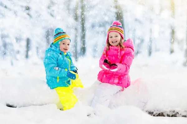 Barn som leker i snö. Barn leka utomhus i vinter snöfall. — Stockfoto