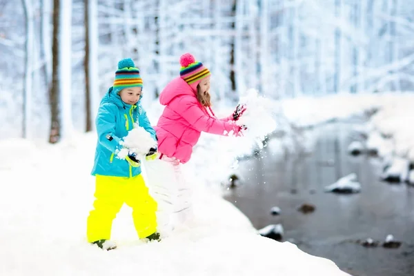 Kids playing in snow. Children play outdoors in winter snowfall. — Stock Photo, Image