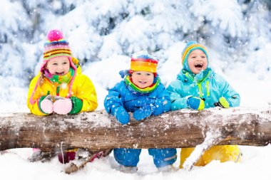 Karda oynayan çocuklar. Çocuklar açık havada kış kar yağışı oynamak.