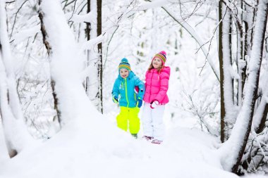 Karda oynayan çocuklar. Çocuklar açık havada kış kar yağışı oynamak.