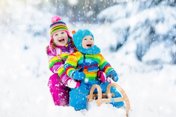 Kinderen op slee rijden. Kinderen rodelen. Sneeuw Winterpret. — Stockfoto