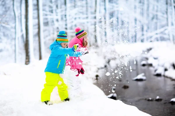 Crianças brincando na neve. Crianças brincam ao ar livre no inverno snowfall . — Fotografia de Stock