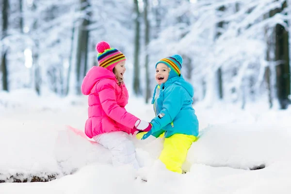 Crianças brincando na neve. Crianças brincam ao ar livre no inverno snowfall . — Fotografia de Stock