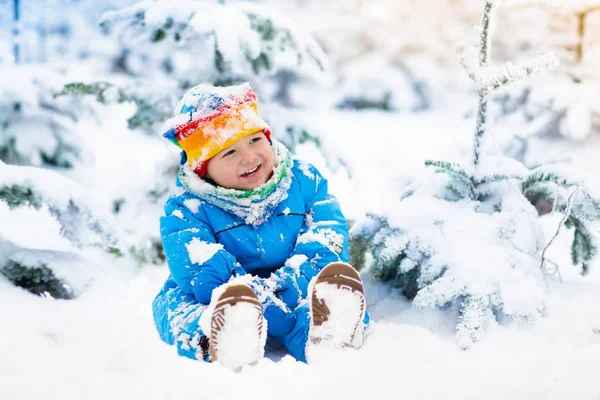 Baby spela med snö på vintern. Barn i snöig park. — Stockfoto