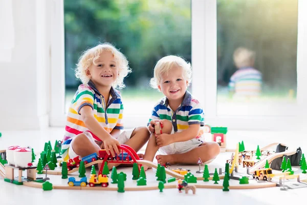 Los niños juegan con el tren de juguete. Ferrocarril de madera . —  Fotos de Stock