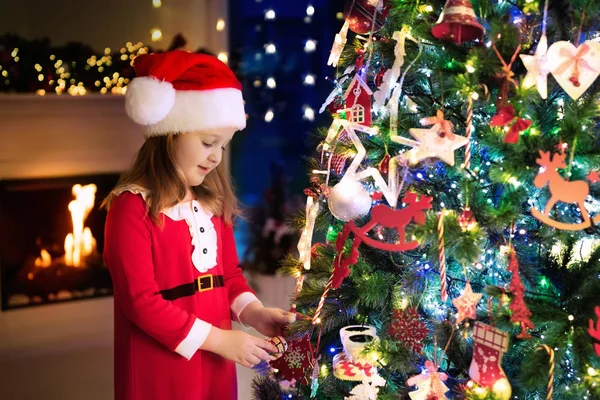 Niño en el árbol de Navidad. Niño en la chimenea en la víspera de Navidad —  Fotos de Stock