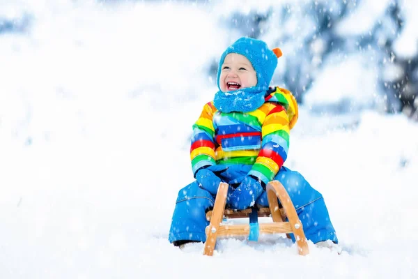 男孩在雪橇上。滑雪橇的孩子。孩子与雪橇 — 图库照片