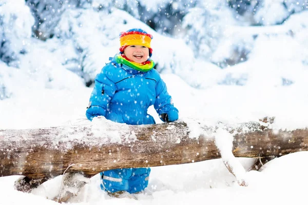 Baby playing with snow in winter. Child in snowy park. — Stock Photo, Image