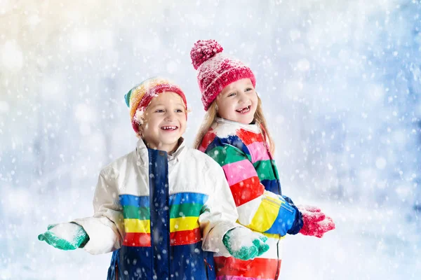 Crianças brincando na neve. Crianças brincam ao ar livre no inverno snowfall . — Fotografia de Stock