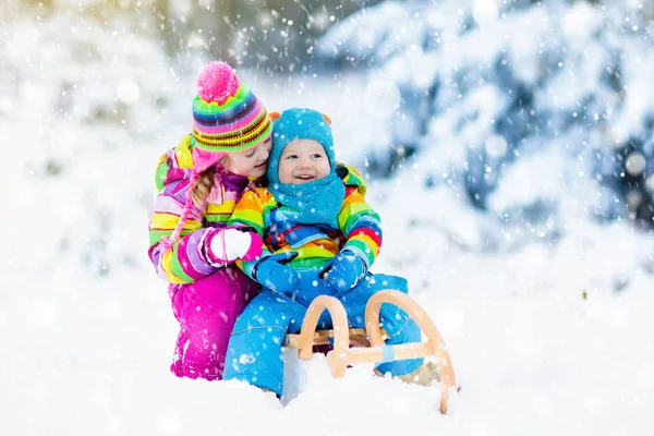 Miúdos em viagem de trenó. Crianças a patinar. Inverno neve diversão . — Fotografia de Stock