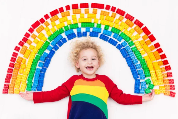 Niño jugando con arco iris bloques de plástico juguete — Foto de Stock