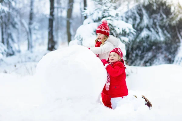 Дети строят снеговика. Дети в снегу. Зимнее веселье . — стоковое фото