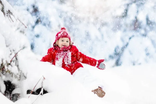 Kind spielt mit Schnee im winter.Junge im verschneiten Park. — Stockfoto