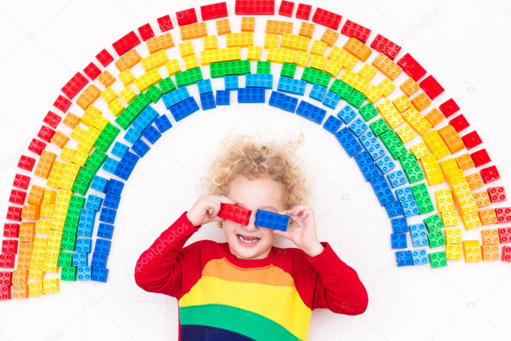 Child playing with rainbow plastic blocks toy