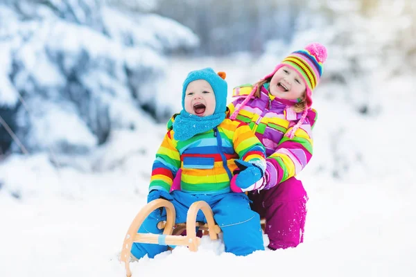 Παιδιά με έλκηθρο που το σέρνουν. Τα παιδιά με έλκηθρο. Διασκέδαση χειμώνα χιόνι. — Φωτογραφία Αρχείου