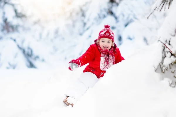 Criança brincando com neve no inverno.Menino no parque nevado . — Fotografia de Stock