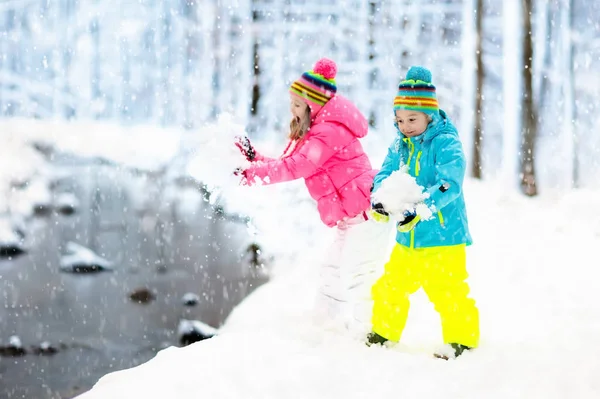 Crianças brincando na neve. Crianças brincam ao ar livre no inverno snowfall . — Fotografia de Stock