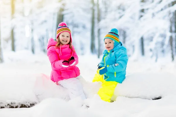 Crianças brincando na neve. Crianças brincam ao ar livre no inverno snowfall . — Fotografia de Stock