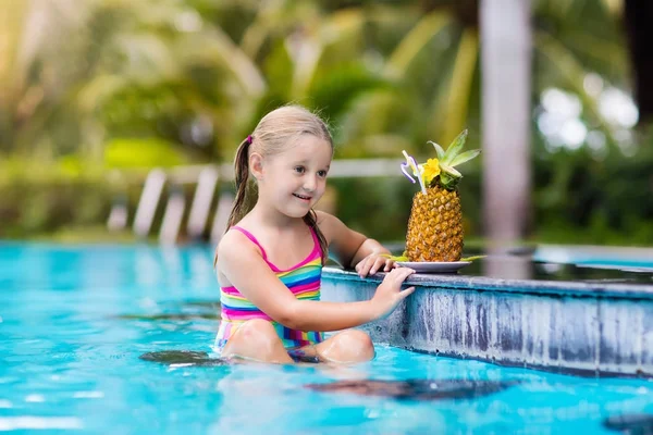 Criança com suco de abacaxi no bar da piscina — Fotografia de Stock