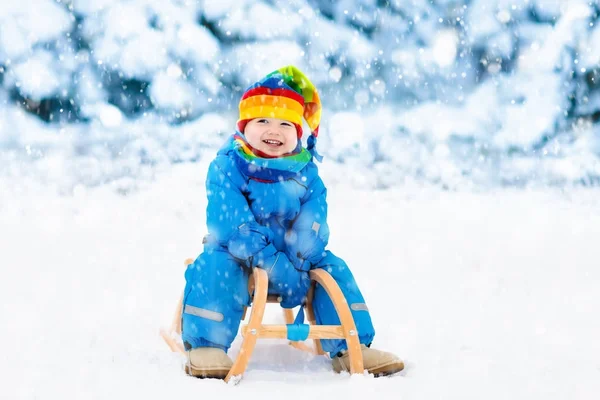 男孩在雪橇上。滑雪橇的孩子。孩子与雪橇 — 图库照片
