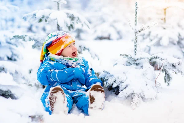 Bambino che gioca con la neve in inverno. Bambino nel parco innevato . — Foto Stock