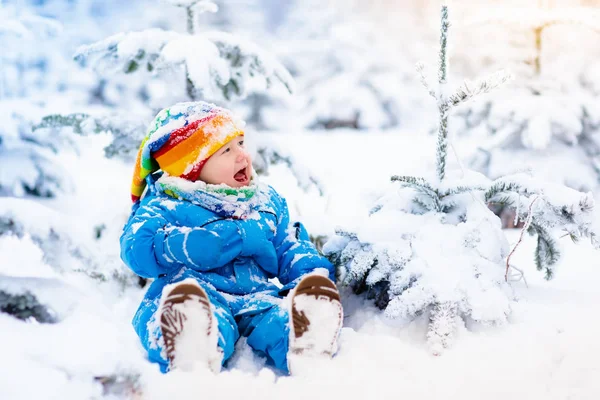 Baby spelen met sneeuw in de winter. Kind in besneeuwde park. — Stockfoto