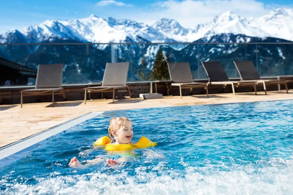 Child in outdoor swimming pool of alpine resort — Stock Photo, Image