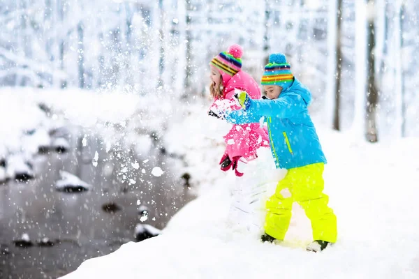 Дети играют на снегу. Дети играют на свежем воздухе в зимний снег . — стоковое фото
