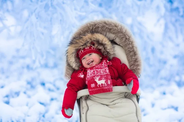 Baby in kinderwagen in winter park met sneeuw — Stockfoto