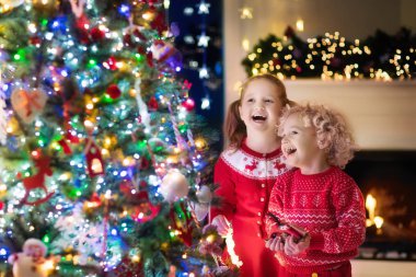 Çocuklar, Noel ağacı. Çocuklar, Noel arifesinde şömine