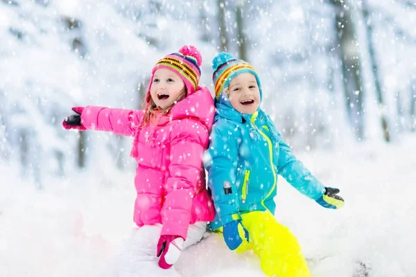 Crianças brincando na neve. Crianças brincam ao ar livre no inverno snowfall . — Fotografia de Stock