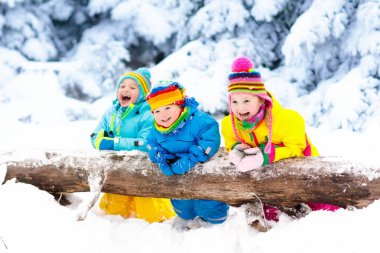 Karda oynayan çocuklar. Çocuklar açık havada kış kar yağışı oynamak.