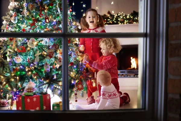 孩子们在圣诞树上。孩子们在圣诞节前夕的壁炉 — 图库照片