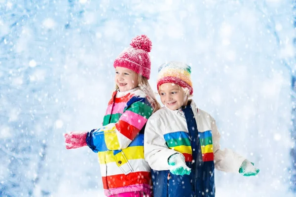 Barn som leker i snö. Barn leka utomhus i vinter snöfall. — Stockfoto