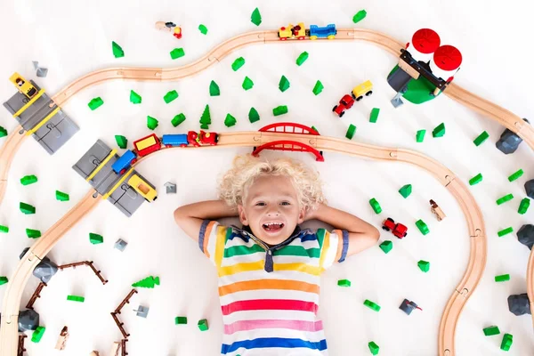 Kind met speelgoed trein. Houten spoorlijn van kinderen. — Stockfoto