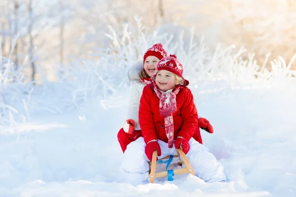 Barnen leker i snön. Vinter slädtur för barn — Stockfoto