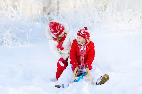 孩子们在雪地里玩。儿童冬季驾雪橇 — 图库照片