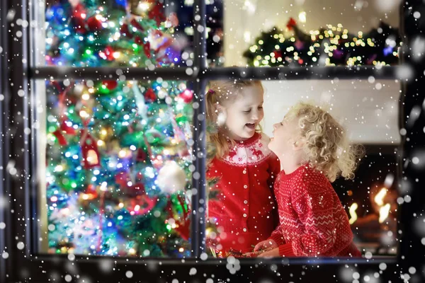 Children at Christmas tree. Kids at fireplace on Xmas eve — Stock Photo, Image