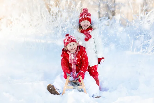 Les enfants jouent dans la neige. Randonnée en traîneau d'hiver pour enfants — Photo