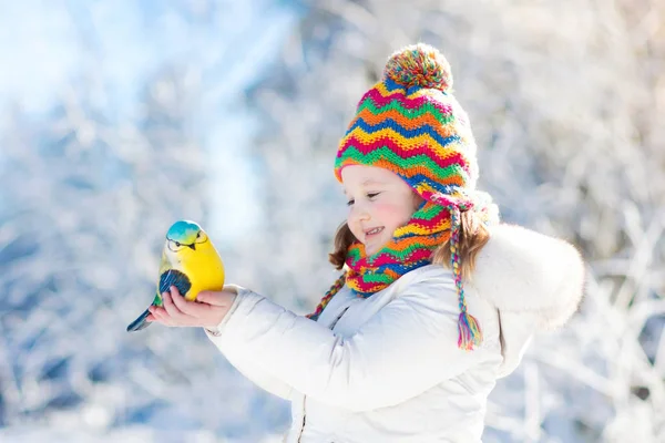 Gyermek etetés a madár-winter park. A gyerekek játszanak a hóban. Természet és — Stock Fotó