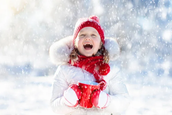 Criança bebendo chocolate quente no parque de inverno. Crianças na neve em Chr — Fotografia de Stock