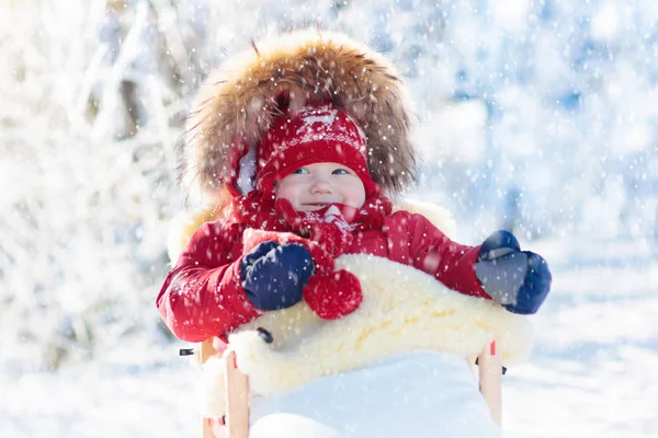 Trineo y diversión de nieve para los niños. Bebé trineo en el parque de invierno . —  Fotos de Stock