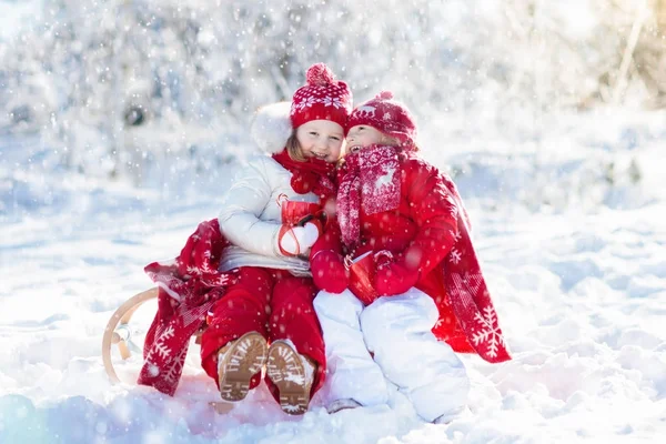 Bambini slittino nella foresta invernale. I bambini bevono cioccolata calda nella neve — Foto Stock