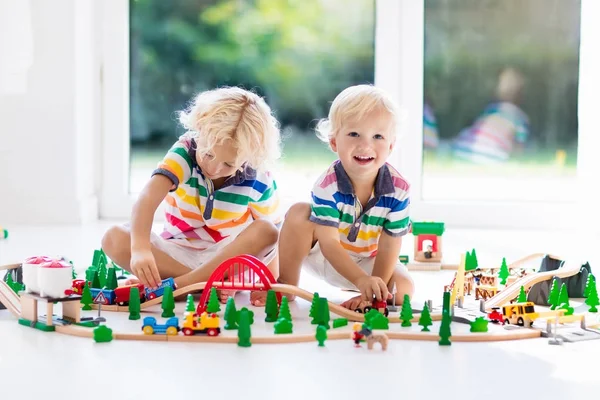 子供は、おもちゃの電車で遊ぶ。子供の木製の鉄道. — ストック写真