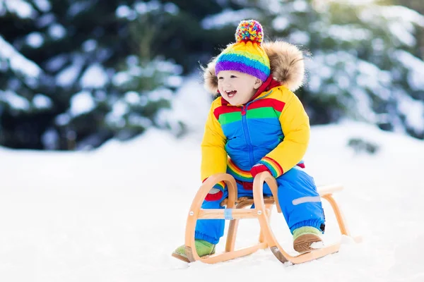 Junge auf Schlittenfahrt. Kinderrodeln. Kind mit Schlitten — Stockfoto