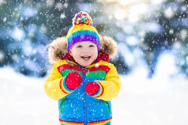 Criança brincando com neve no inverno. Crianças ao ar livre . — Fotografia de Stock