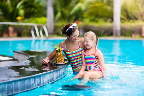 Madre e hijo beben jugo en la piscina —  Fotos de Stock